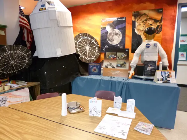 A few papers with drawings, digital weighing machine and a torch are on table with two chairs....
