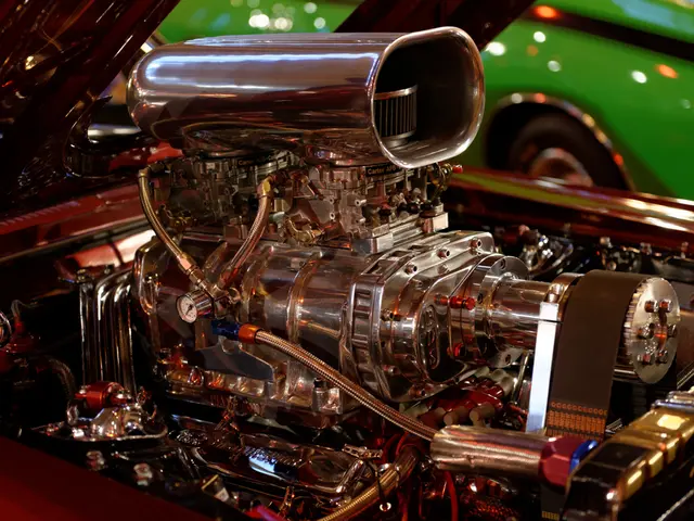 Here we can see engine parts of a vehicle and some other parts. In the background there is a car.